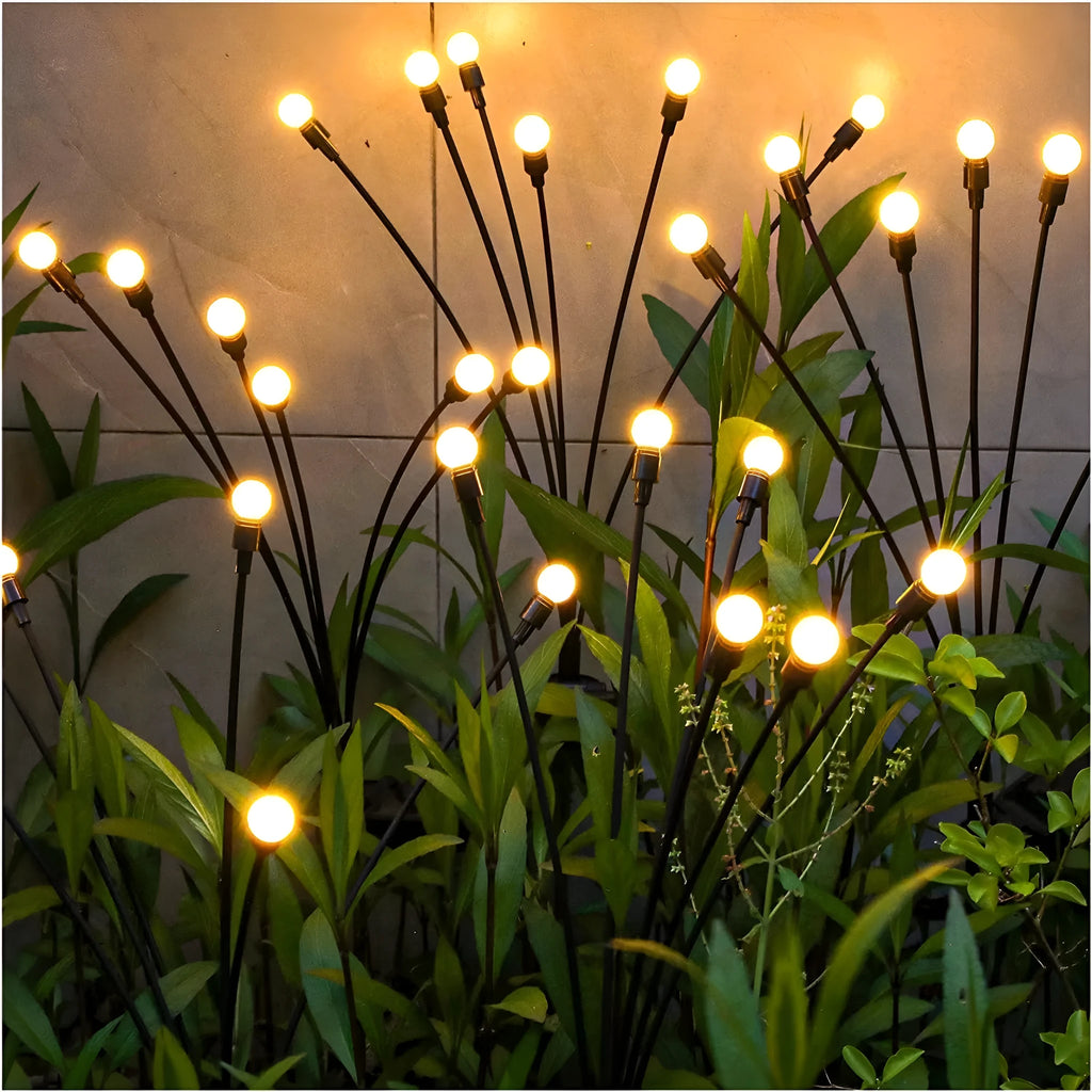 Set of solar-powered LED garden spike lights with multiple heads on stainless steel stakes for lawn or pathway.