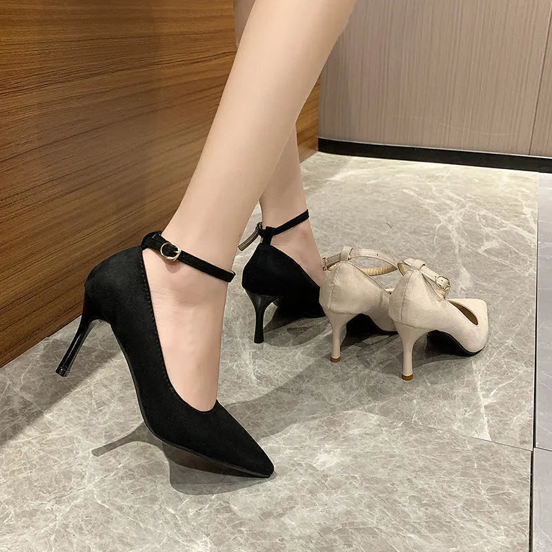 Women's black stiletto heel pump shoes with skull pattern and buckle detail on a white background