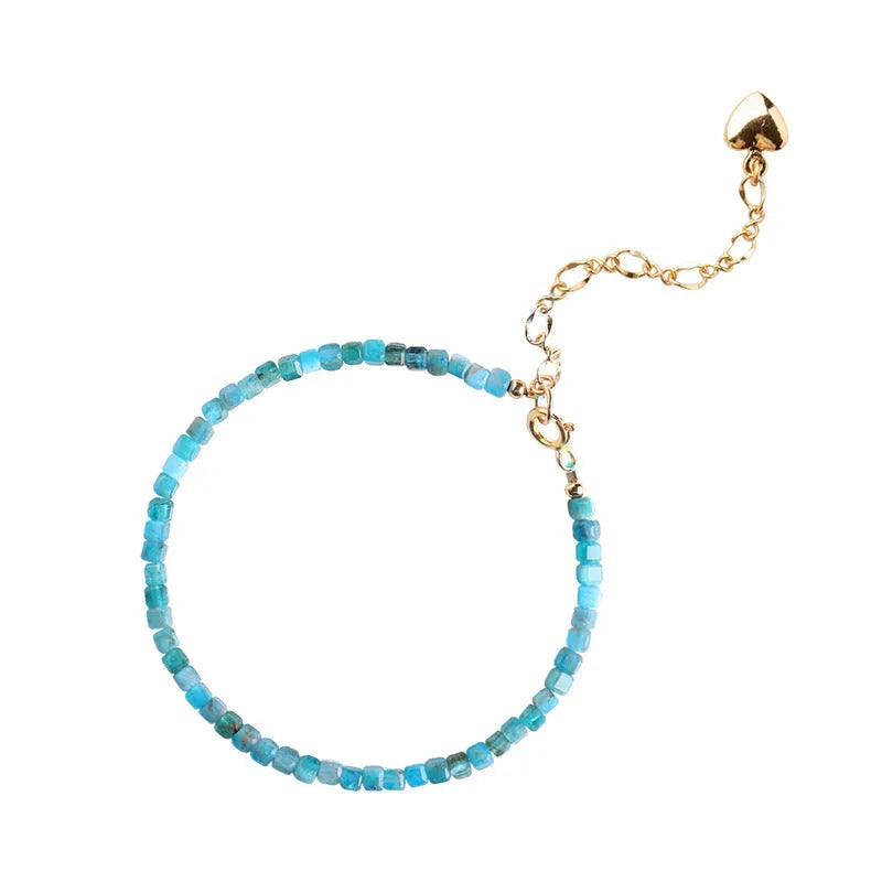 Natural blue apatite crystal bracelet with diamond-shaped beads, blue and grey colour, on a white background