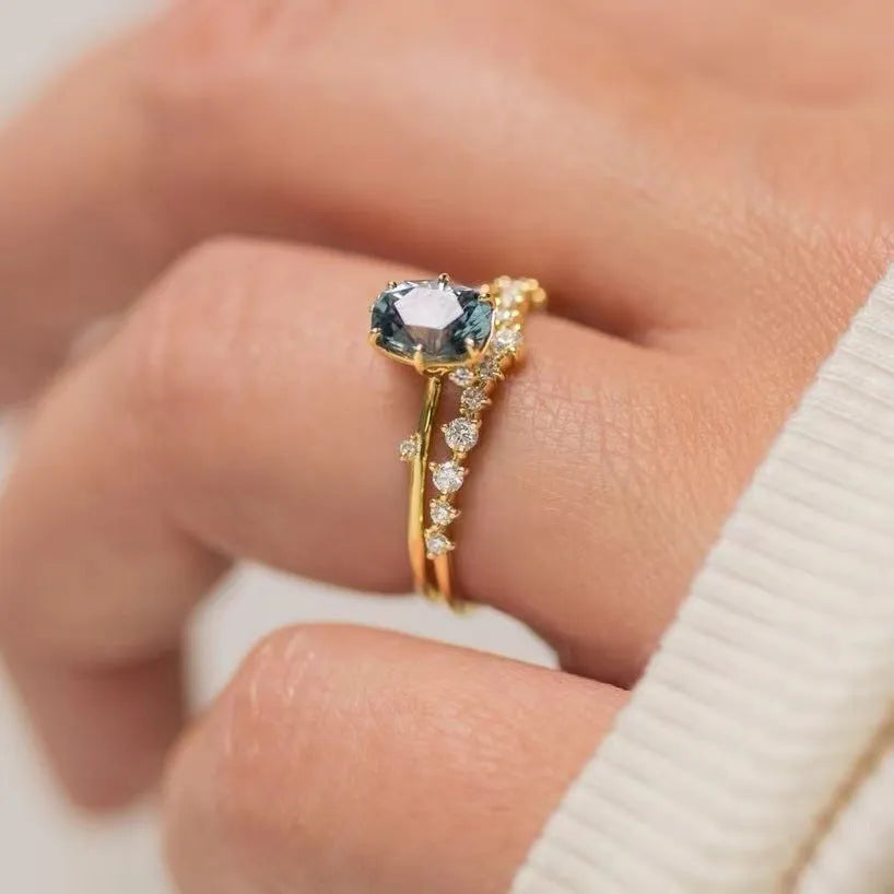 Gold-plated flower-shaped ring with green zircon stones on a model finger