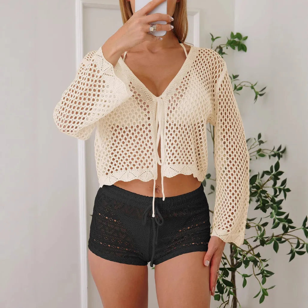 Short apricot women's cardigan blouse with bell sleeves made from thin hollow woven fabric.
