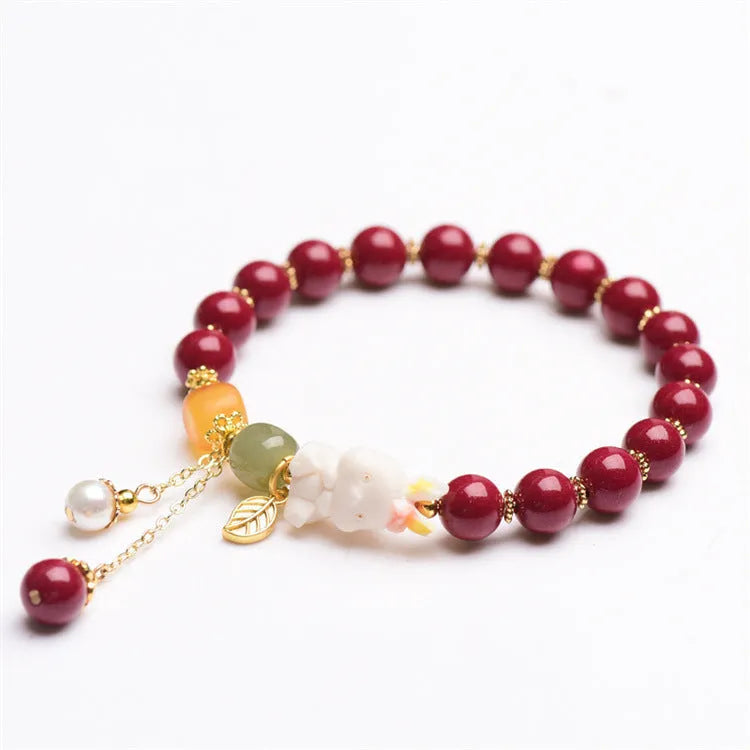 Women's bracelet with natural beeswax, purple gold sand beads, and a red cinnabar rabbit charm.