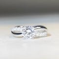 Silver moissanite ring with 1 karat stone and cross twisted arm geometric design