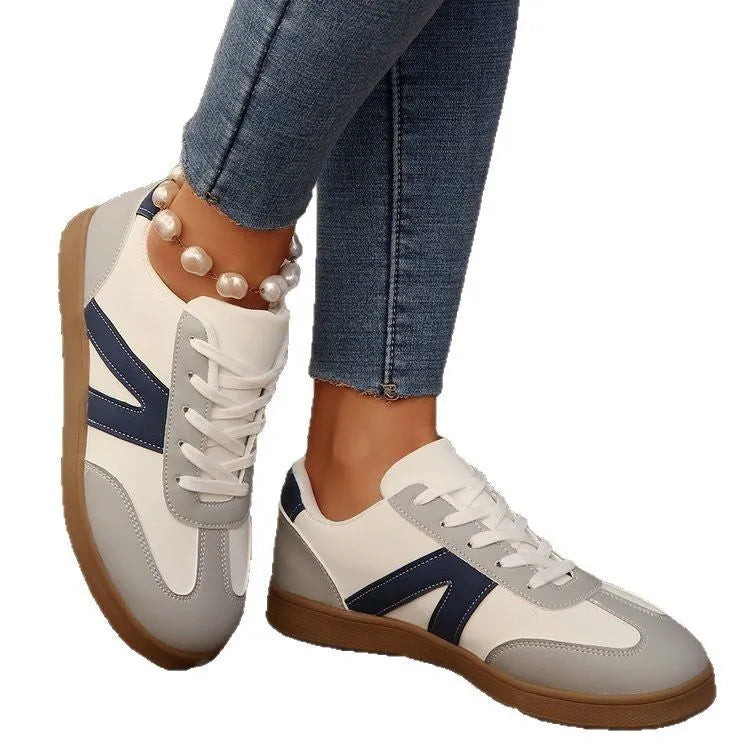 Women's blue flat German training shoes with artificial PU upper and rubber sole, low-top profile, side view