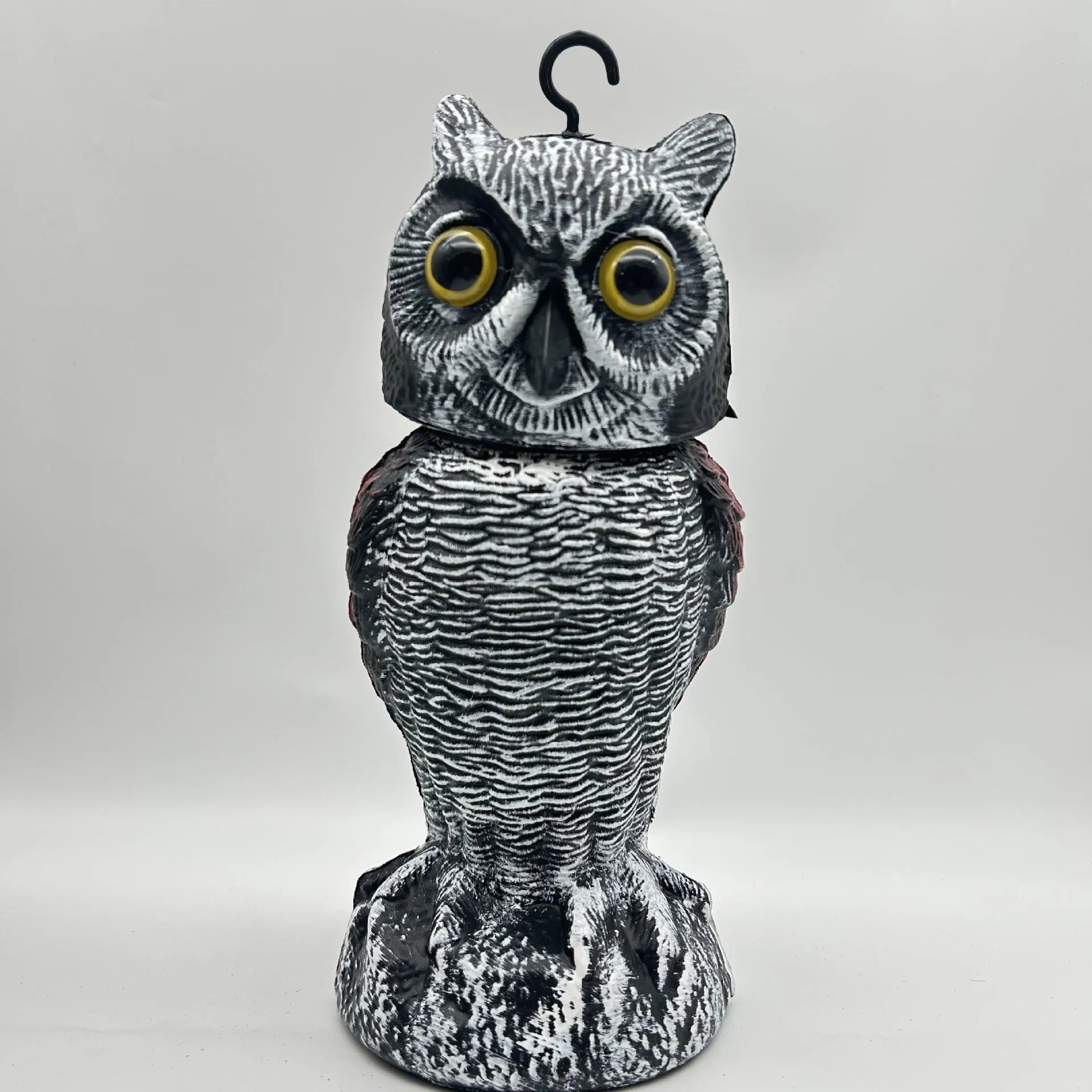 Artificial owl garden ornament with shaking head for bird deterrent on patio