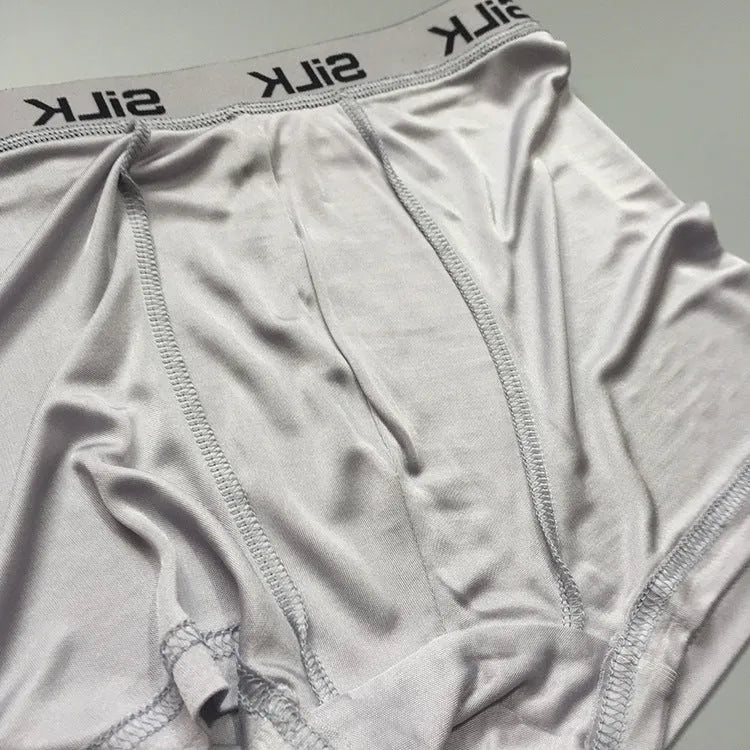 Men's loose fit silk shorts in navy blue, shown on a mid waist.