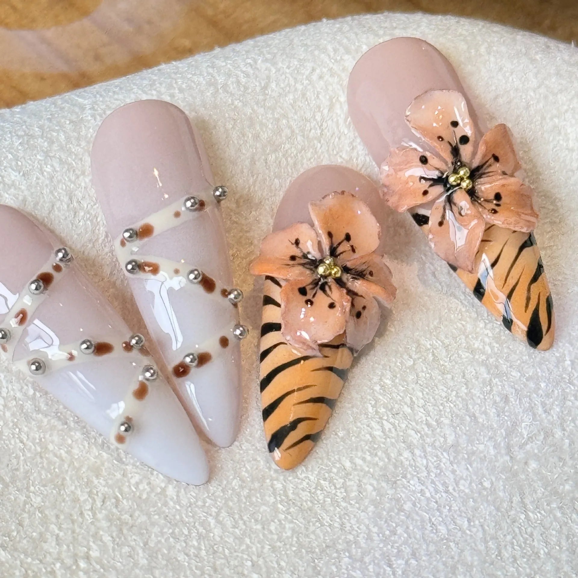 Leopard print false nails with cross and flower designs, shown in long wear armour style
