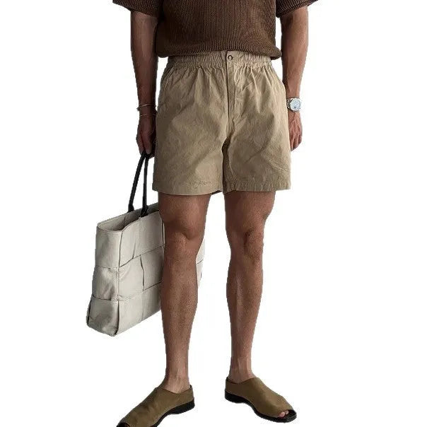 Men's loose fit cotton sports shorts in black, shown on a hanger.