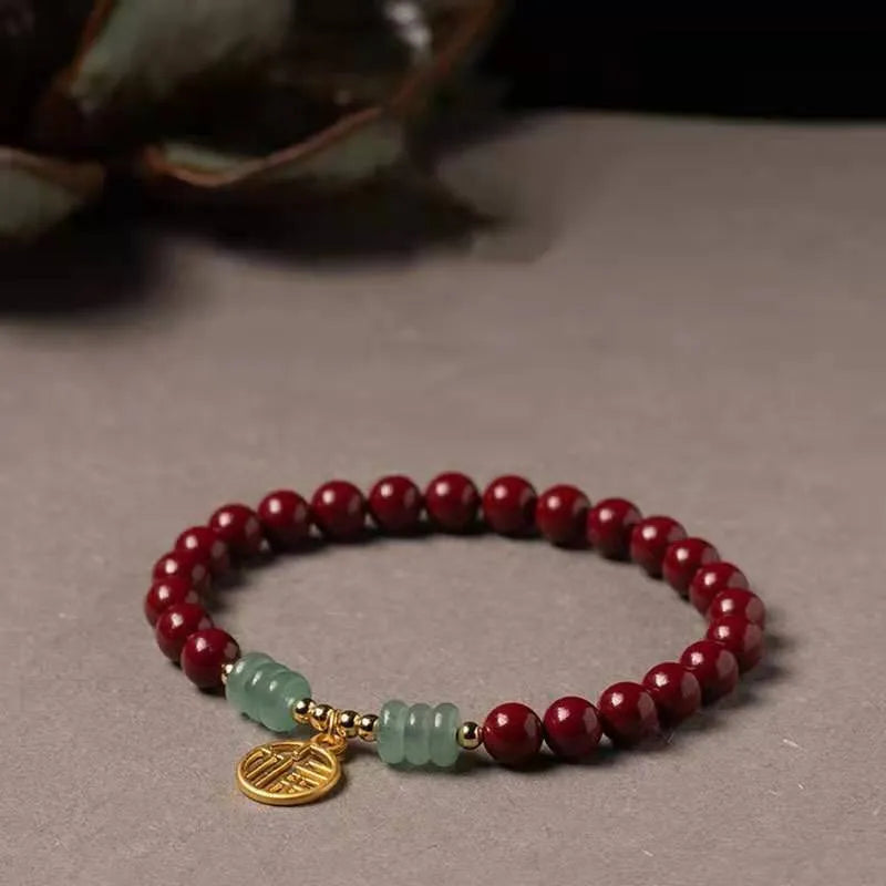 Handmade wave-shaped bracelet featuring cinnabar and copper beads on a wrist.