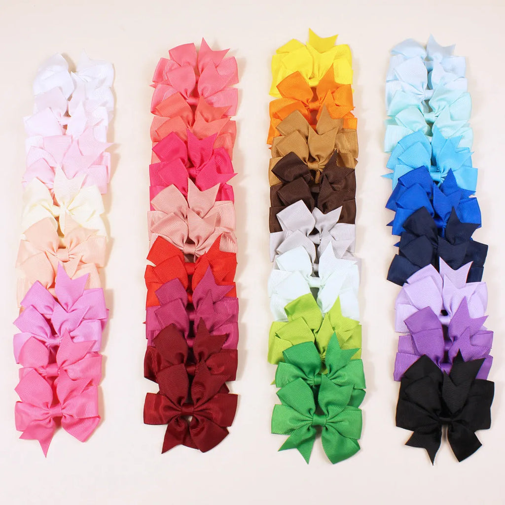 Set of 20 handmade grosgrain ribbon hair bows with alligator clips in assorted colours, each 3 inches long, on a white background