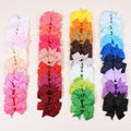 Set of 20 handmade grosgrain ribbon hair bows with alligator clips in assorted colours, each 3 inches long, on a white background