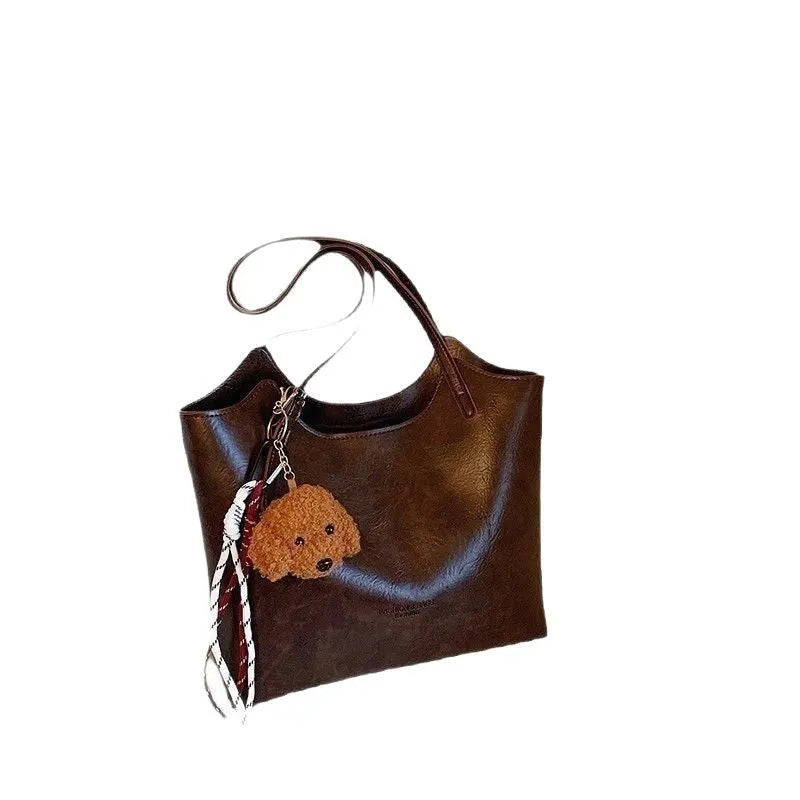 Women's PU commuter shoulder bag in black with stitching details and optional ribbon pendant, horizontal square shape