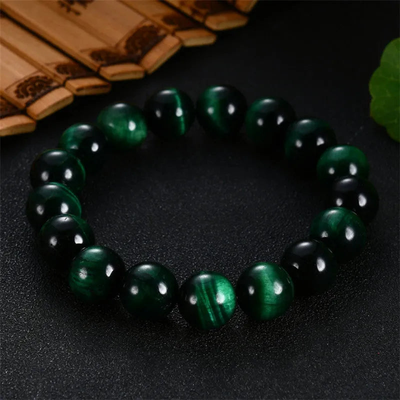 Green polished Tiger Eye stone bracelet with geometry beads, shown on a wrist.