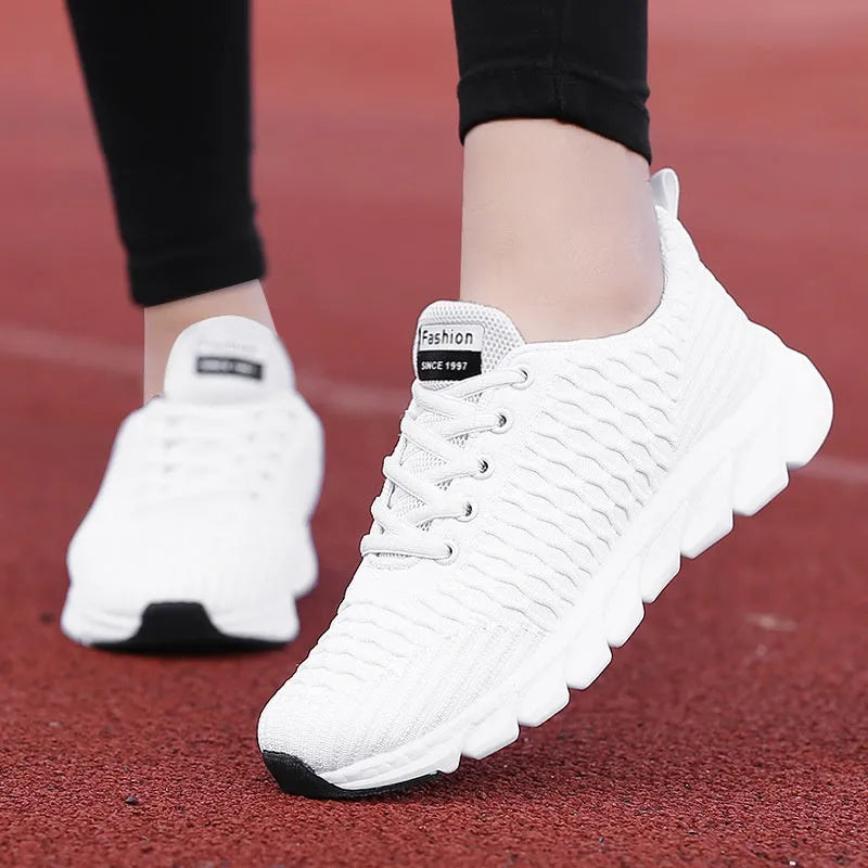 Women's running shoes in black, pink, or white with a fly weave upper and durable sole.