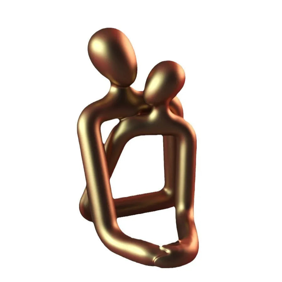 Modern couple resin statue in gold colour placed on a white bookshelf as home decor accent