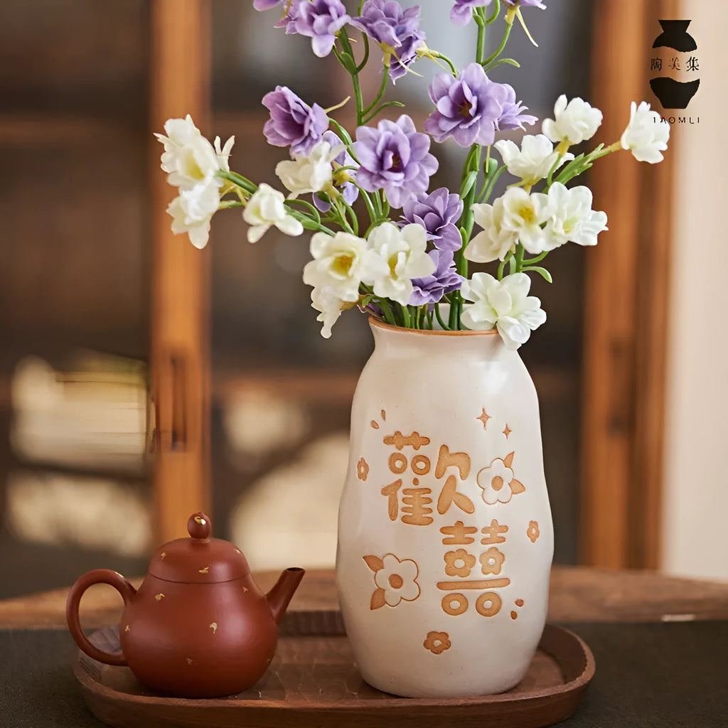 Chinese hand-painted ceramic joy vase with symbolic motifs on wooden desk