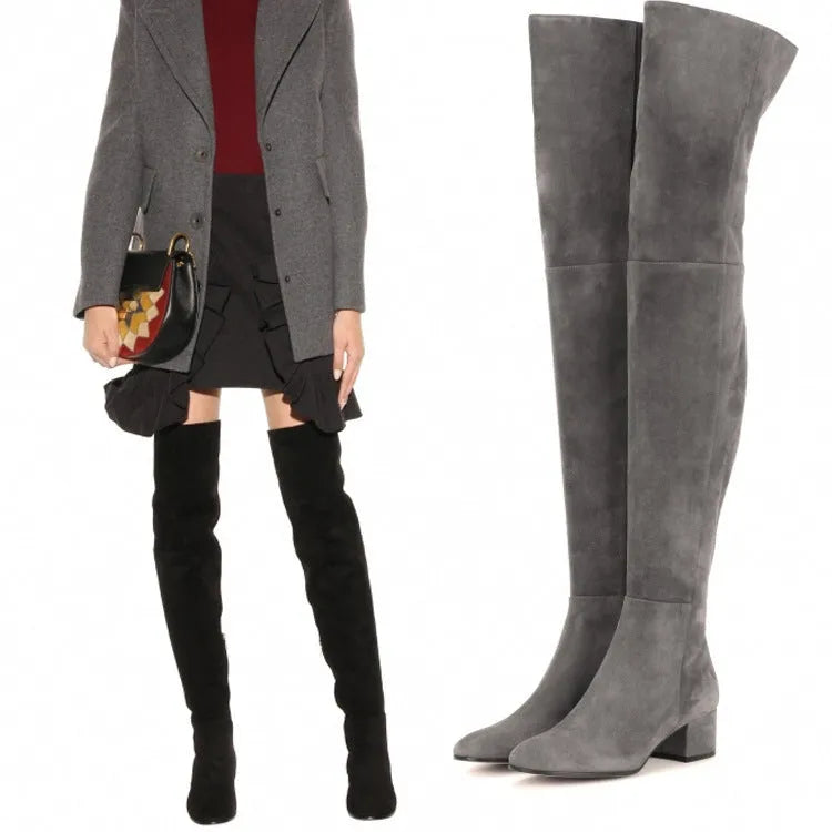 Grey women's suede over-the-knee flat boots with a pointed toe and low thick heel on a white background.