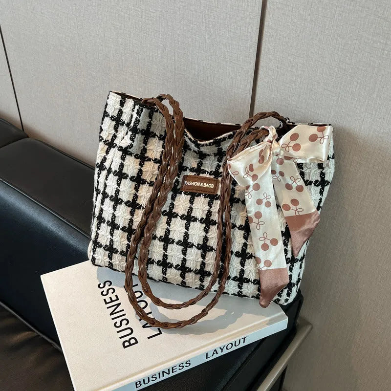Black woven wool shoulder bag with horizontal square shape showing internal organiser compartments