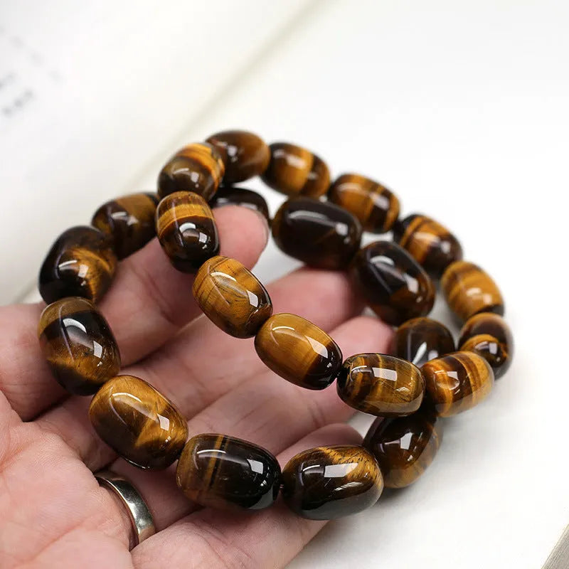 Natural yellow tigereye bracelet with sunny cat eye effect, ball beads in 11x16mm size on light background