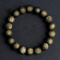 Natural obsidian crater ball bracelet in gold or silver meteorite finish on a wrist.