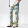 Yellow and blue retro patchwork jeans with a splash-ink damaged design, shown on a mannequin.