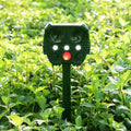 Green solar-powered ultrasonic animal repeller with LED strobe lights for outdoor pest control.
