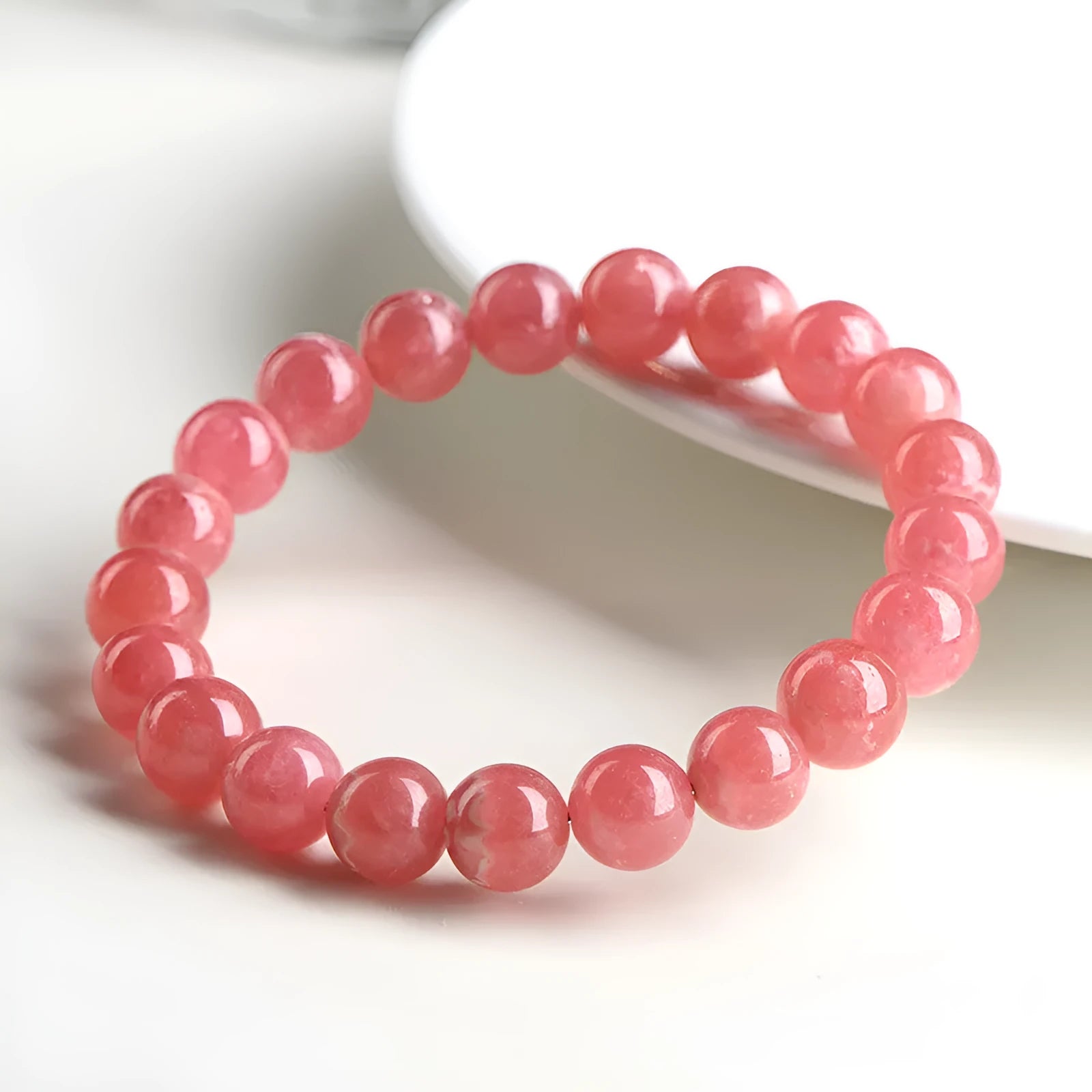 Women's red rhodochrosite crystal bracelet with geometric beads and a longevity lock clasp.