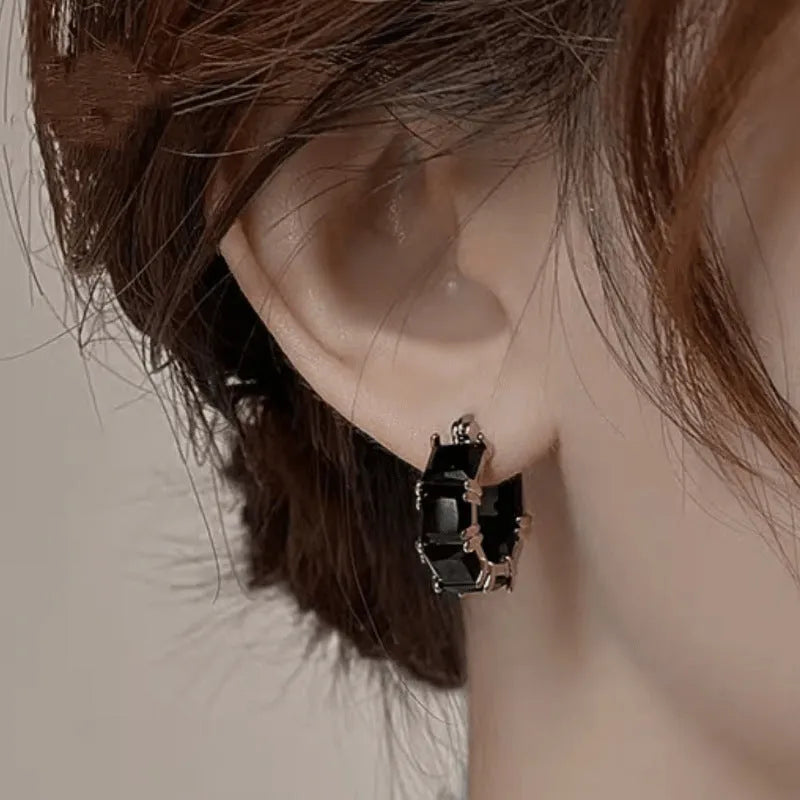 Geometric U-shaped gold earrings with round black zircon crystals