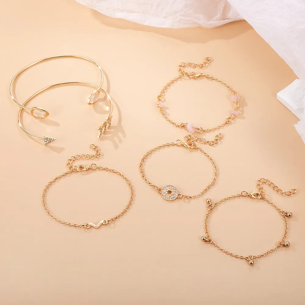 Women's gold colour bracelet set with 6 pieces showing water drop V-shaped pendants and drill arrow designs