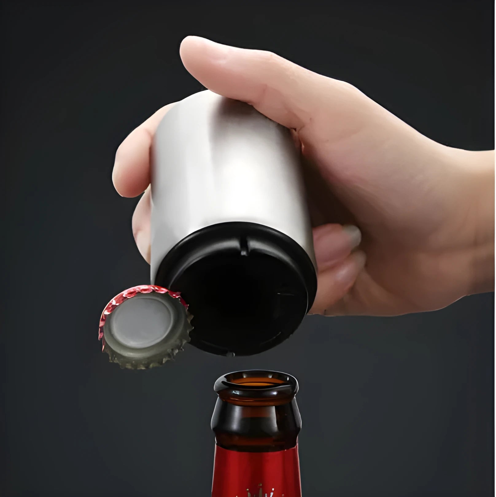 Automatic stainless steel beer bottle opener with magnetic cap catch on a table
