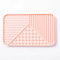 Silicone pet licking mat in gray with suction cup base on a smooth floor