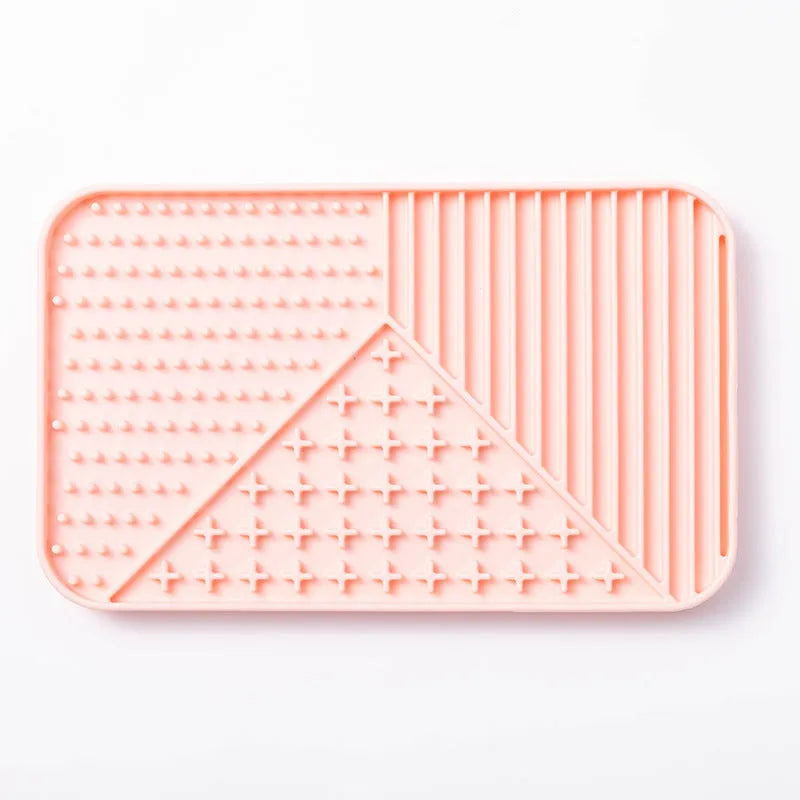Silicone pet licking mat in gray with suction cup base on a smooth floor