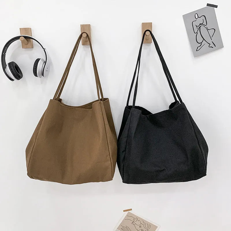 Solid colour women's canvas handbag in black with double shoulder straps and external sandwich pocket