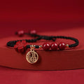 Cinnabar round bead blessing card bracelet with adjustable braided rope on neutral background