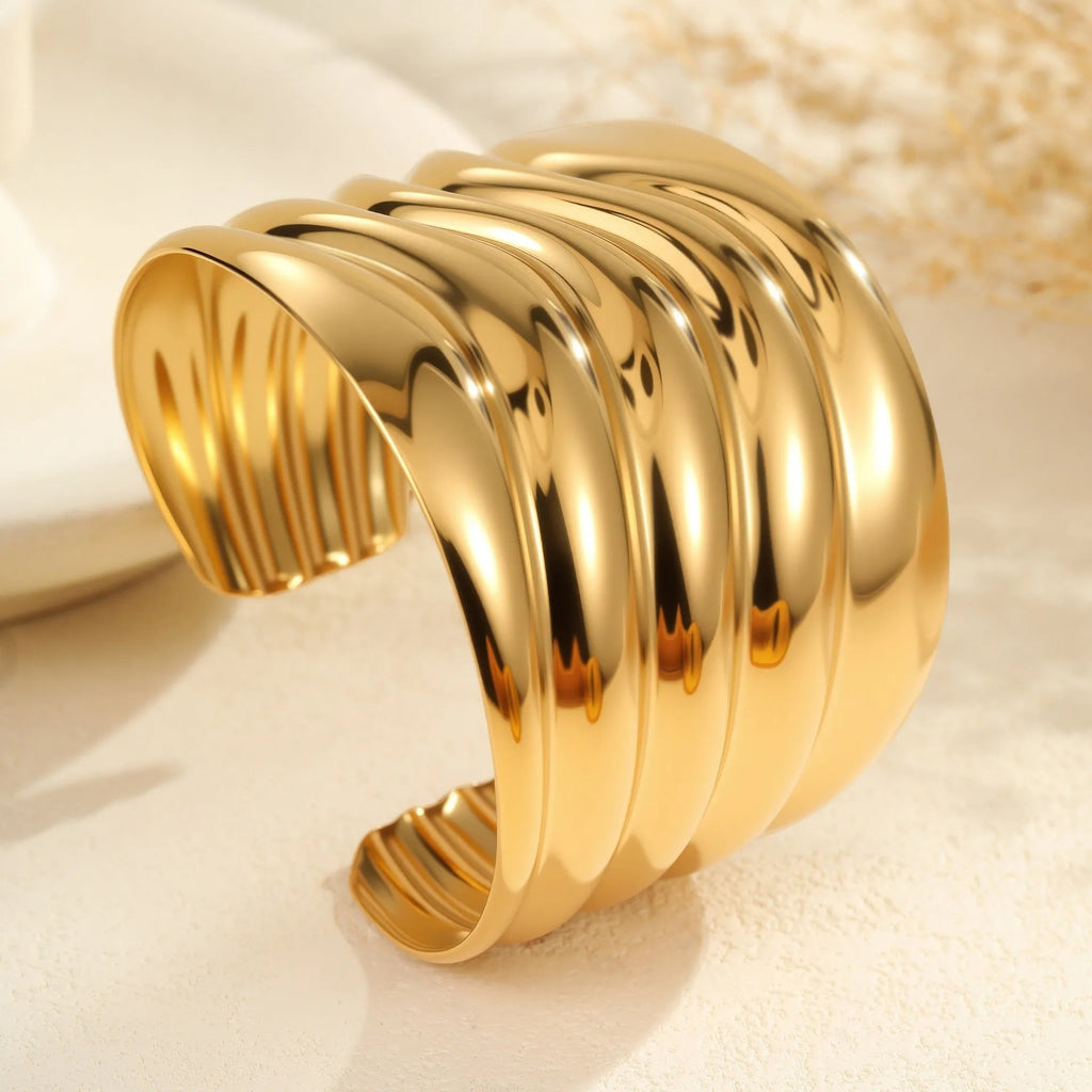 Women's geometric wave bracelet in stainless steel with gold plating and asymmetric design