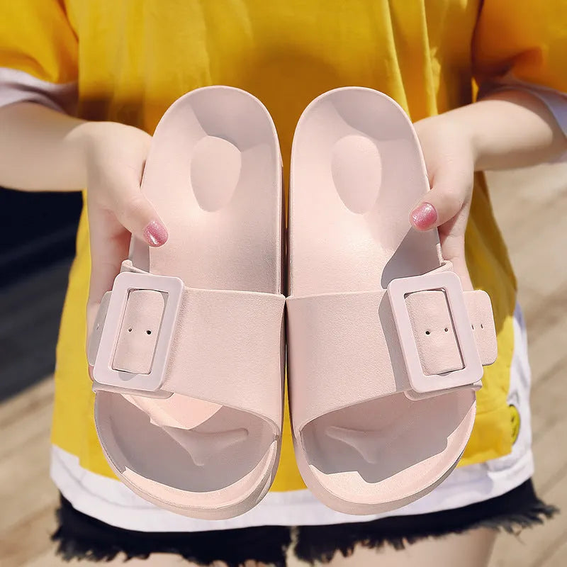 Women's grey blue buckle strap slippers with a soft EVA sole on a light background.