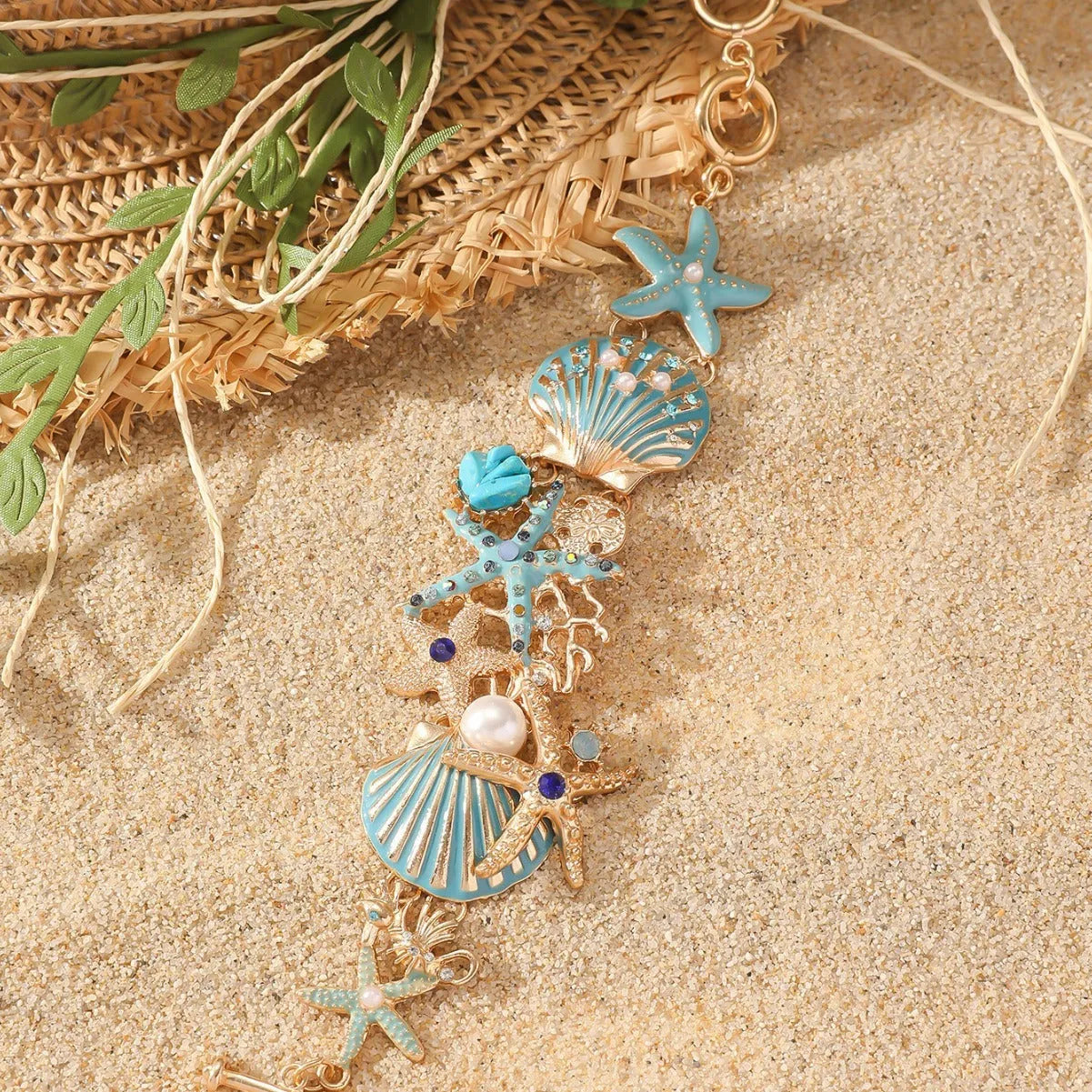 Alloy starfish bracelet with blue coral rhinestone boat anchor charm on a wrist.