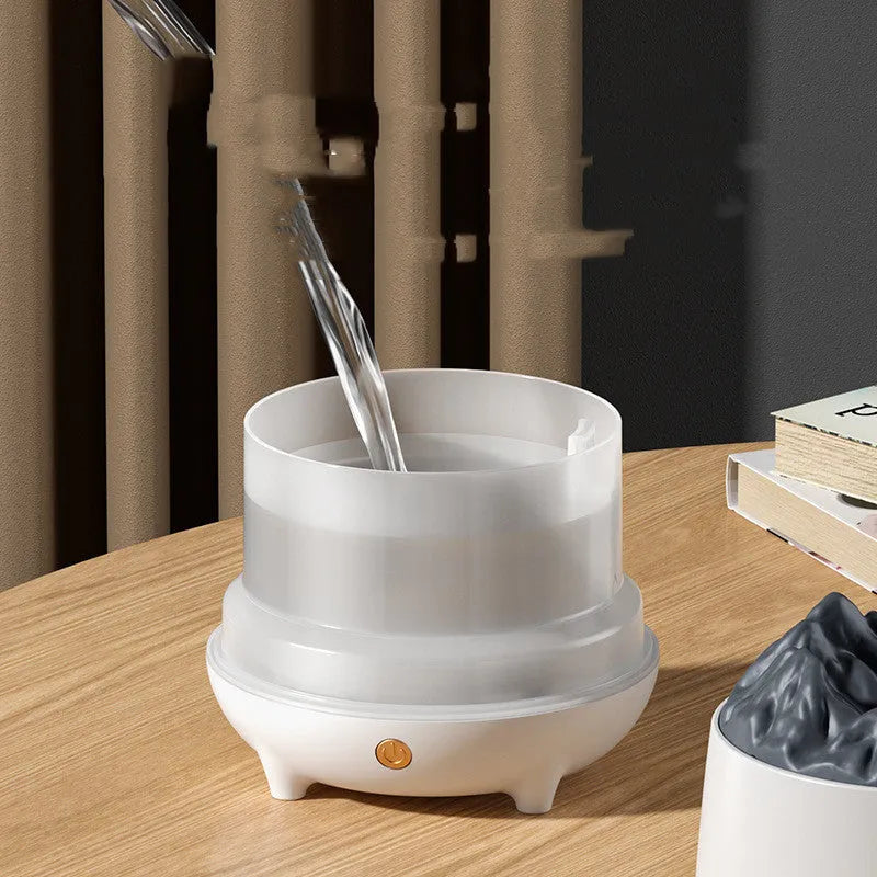 White volcano-shaped ultrasonic humidifier with USB cable on desk in a room