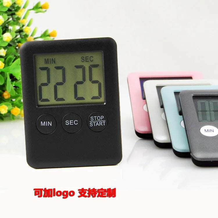 Black and white magnetic kitchen timer clock with digital display on a metal surface.