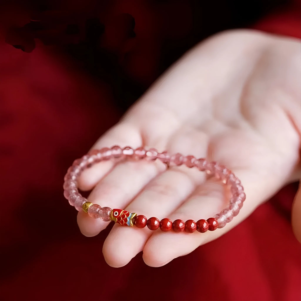Close-up of a women's bracelet with purple cinnabar and pink strawberry quartz beads in a retro design.
