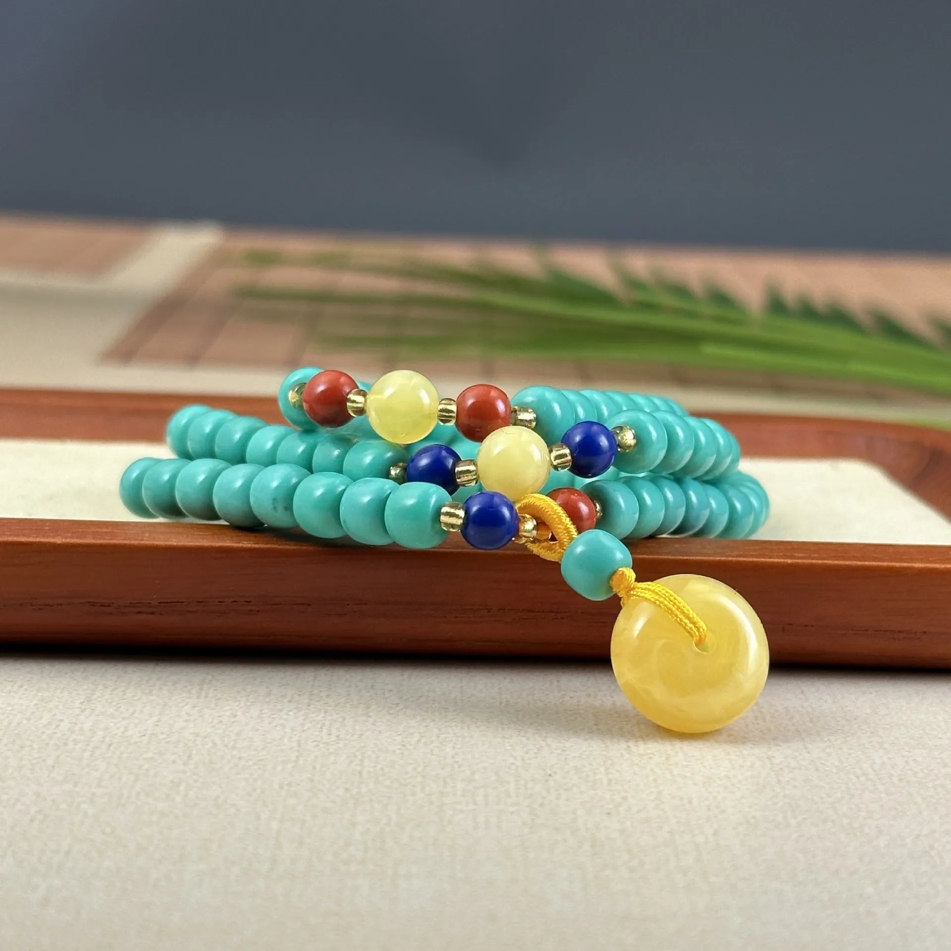 Turquoise stone lucky pendant necklace with hand-woven mesh flower design on a ball bead chain.