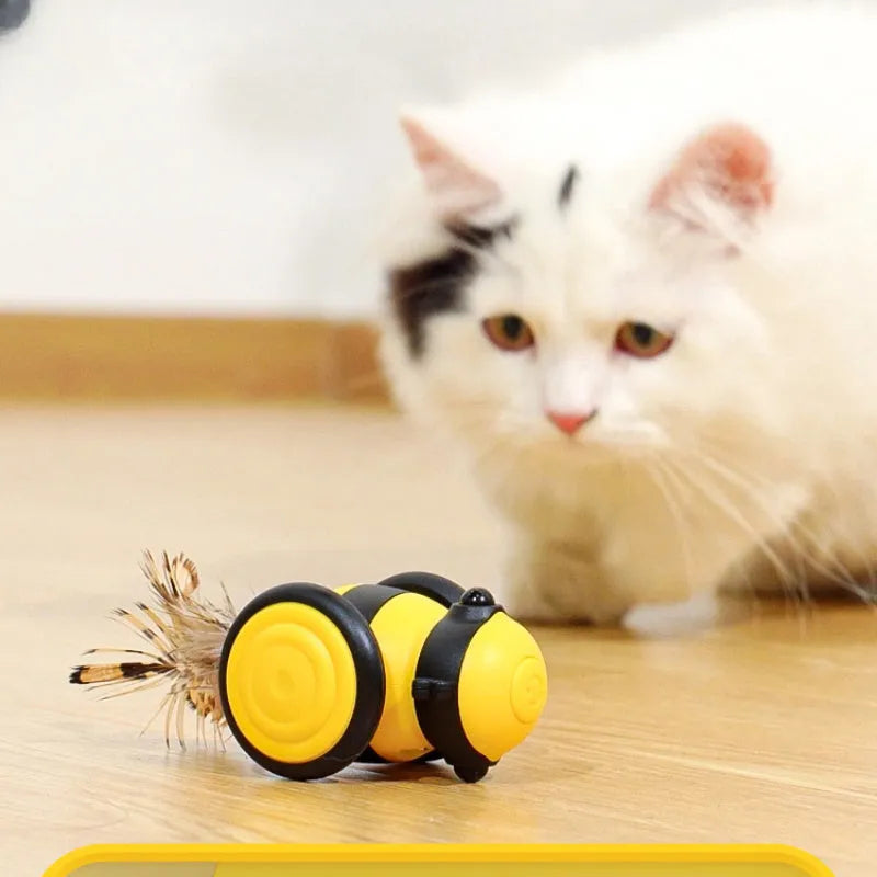 Electric cat car toy in pink with feather teaser stick, moving randomly on a carpet