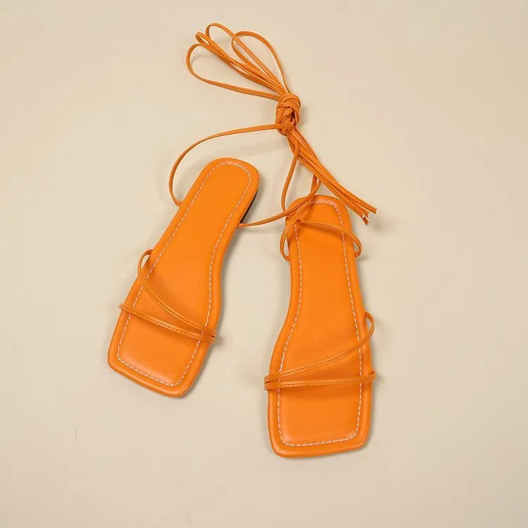 Women's flat sandals with ankle ring bandage detail and front lace-up in square toe design.