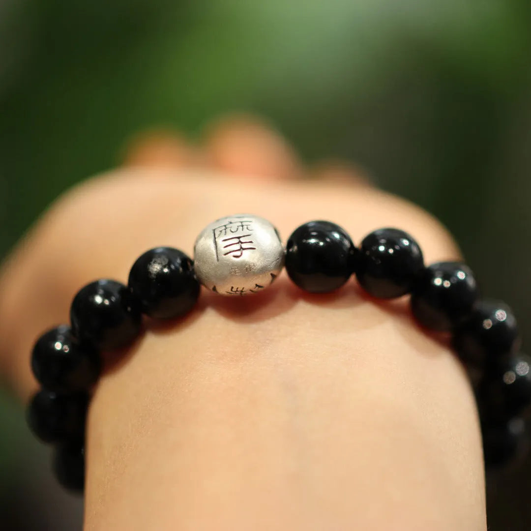 Women's black agate bracelet with sterling silver clasp showing 10mm stones and Chinese style design.