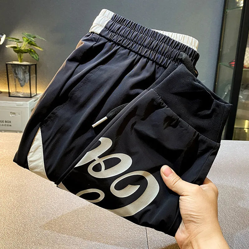 Men's black ultra-thin ice silk ankle banded cropped casual trousers on hanger