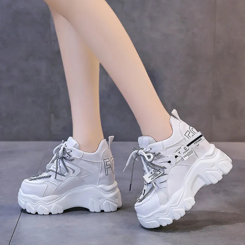 White and black women's low-top platform sports shoes with mesh upper and cross strap.