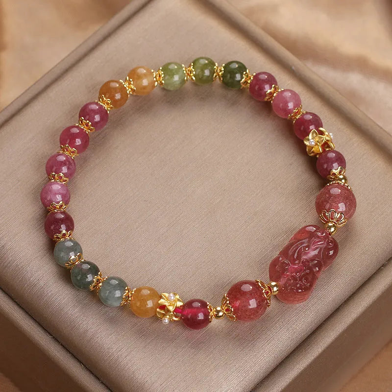 Pink crystal Pi Xiu bracelet with tourmaline and strawberry quartz beads on white background