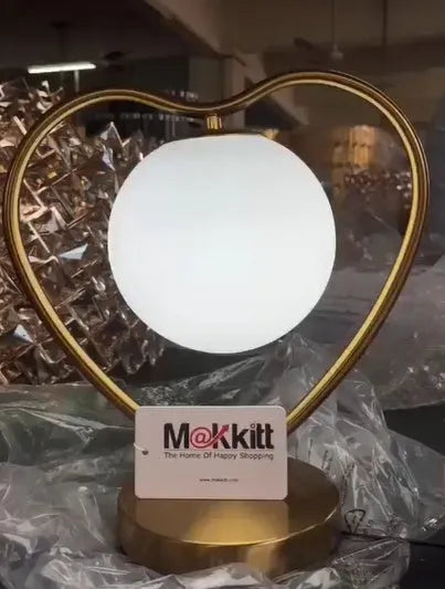 A single heart-shaped table lamp on a surface, showing its decorative design.