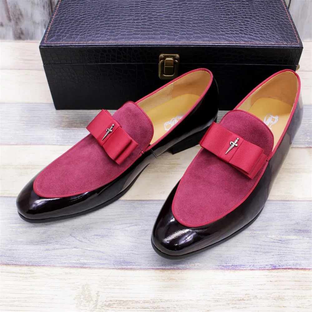 Men's black patent leather dress shoes with a gold tassel detail on the front.