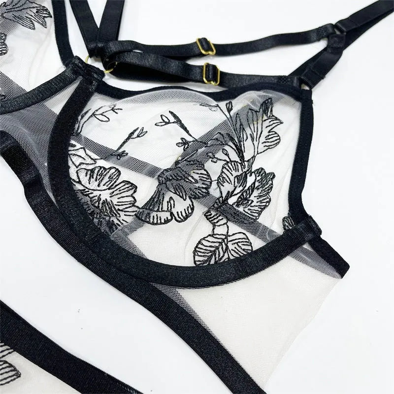 Black women's lace mesh floral print three-piece set with top, trousers, and waist ring on a hanger.